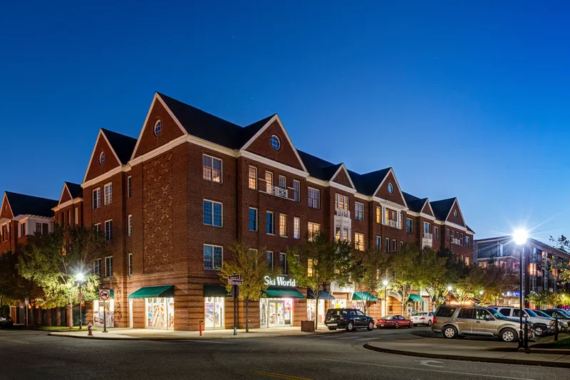 Brick mixed-use building with ground-floor retail at dusk