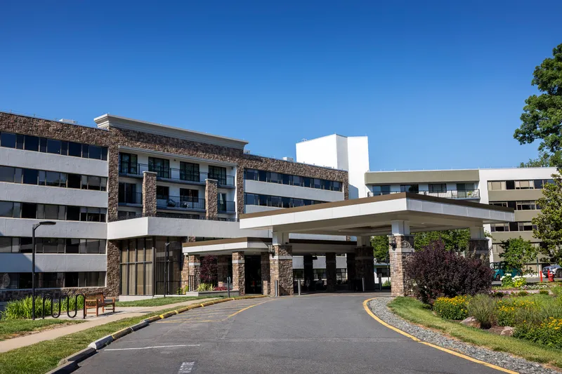 Renovated multi-story building with a covered entry and curved drive