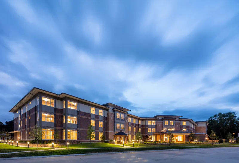 Modern senior living community lit at dusk